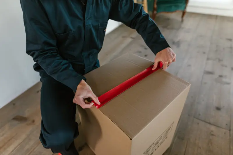 Mover taping a moving box closed